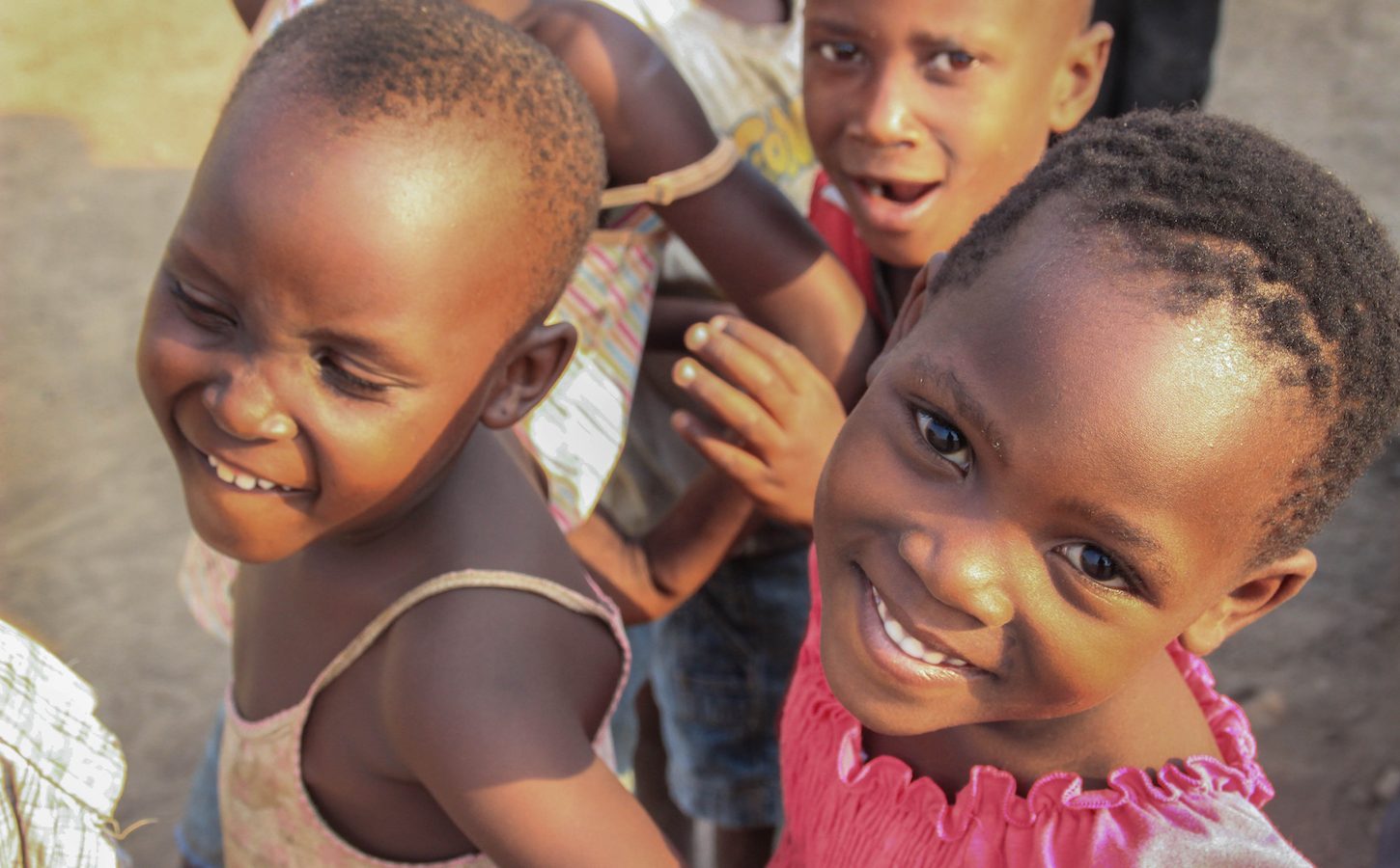 Fort Portal, Uganda - January 27, 2015: African village children playing near the lake shore in the suburb of Fort Portal